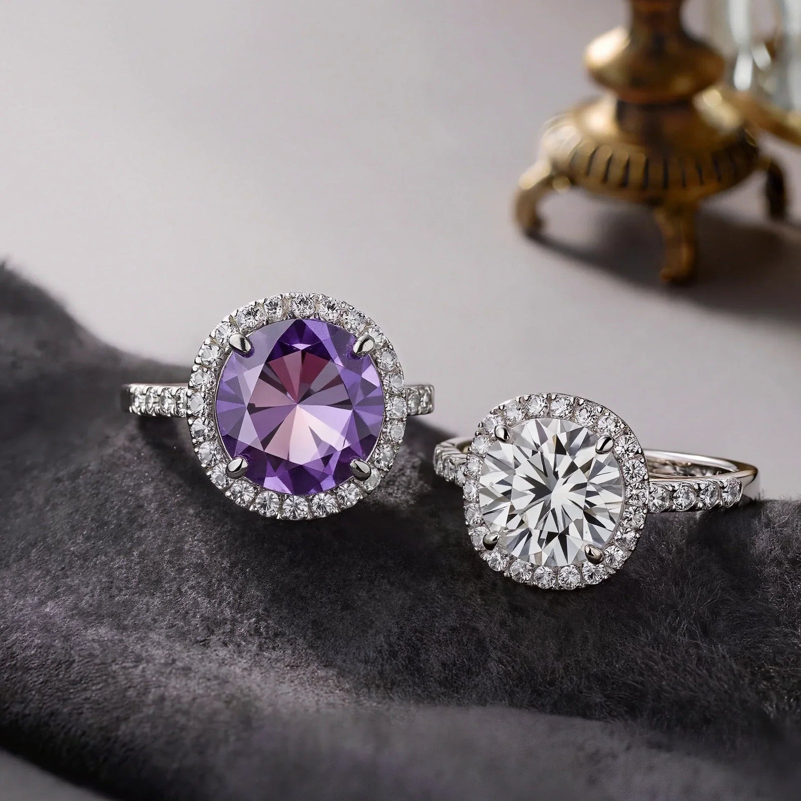 Comparison of a vibrant purple amethyst halo ring and a brilliant colorless diamond engagement ring on a dark elegant fabric.