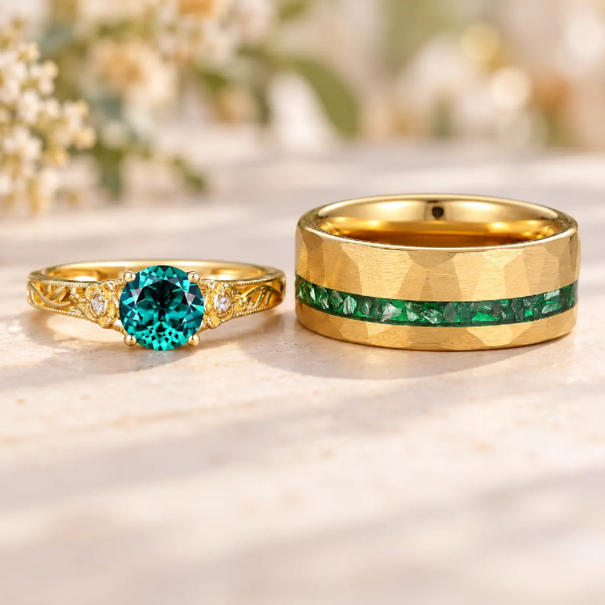 **Alt text：** Gold wedding ring set with a teal gemstone engagement ring and matching green inlay wedding band on a soft ivory marble surface.